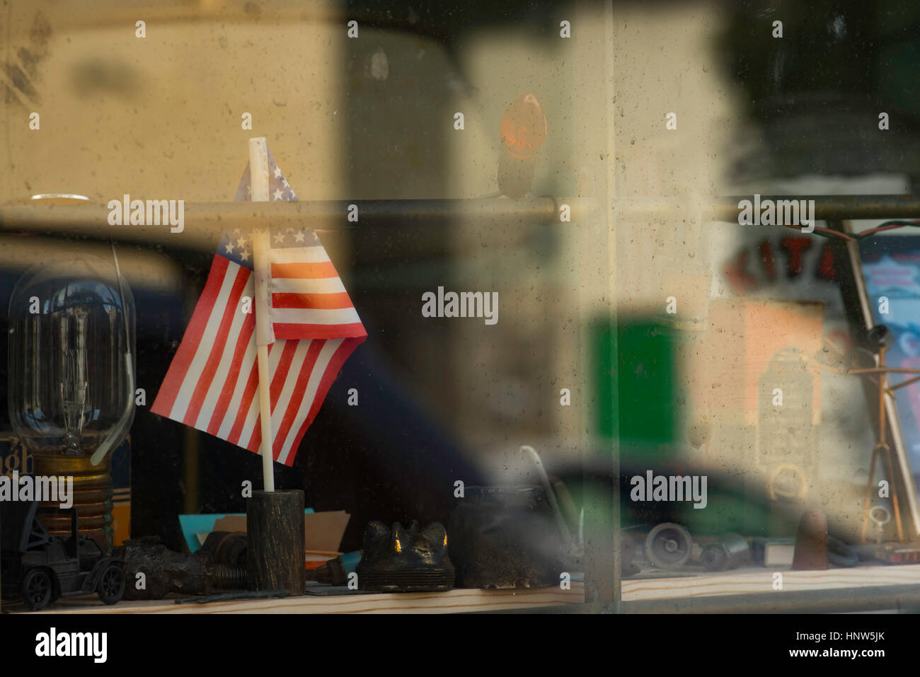 Un piccolo giocattolo americano bandiera è visualizzato in un vecchio finestra di memorizzazione Foto Stock