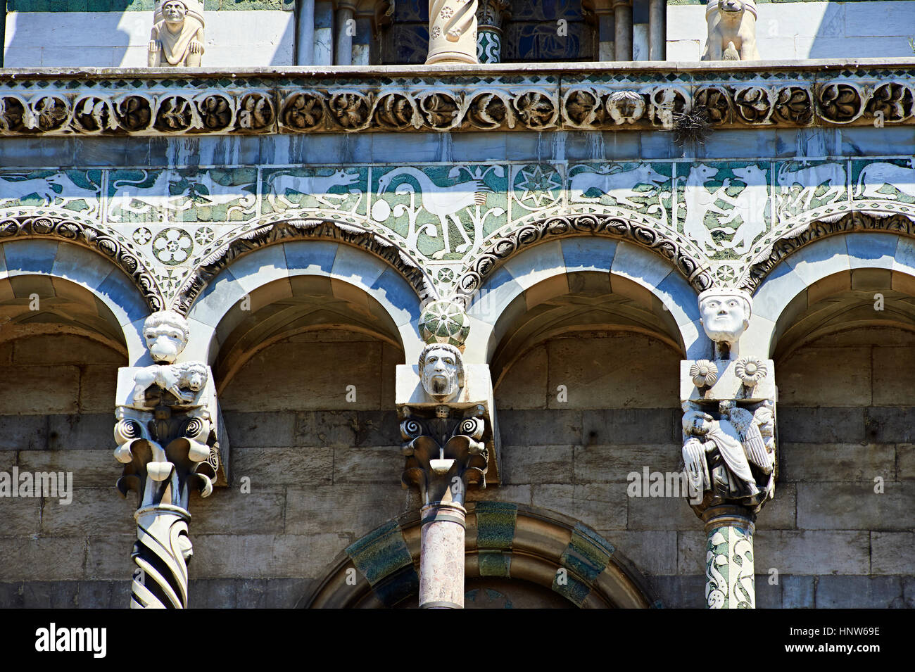 Close up dei portici colonne e statue di San Michele del XIII secolo facciata romanica di San Michele in Foro, Lucca, Toscana, Italia Foto Stock