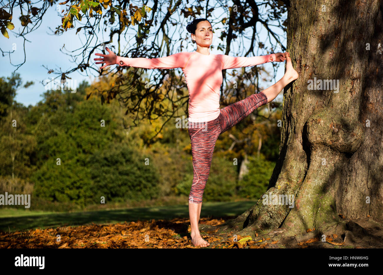 Donna facendo yoga nel parco sulla giornata autunnale Foto Stock