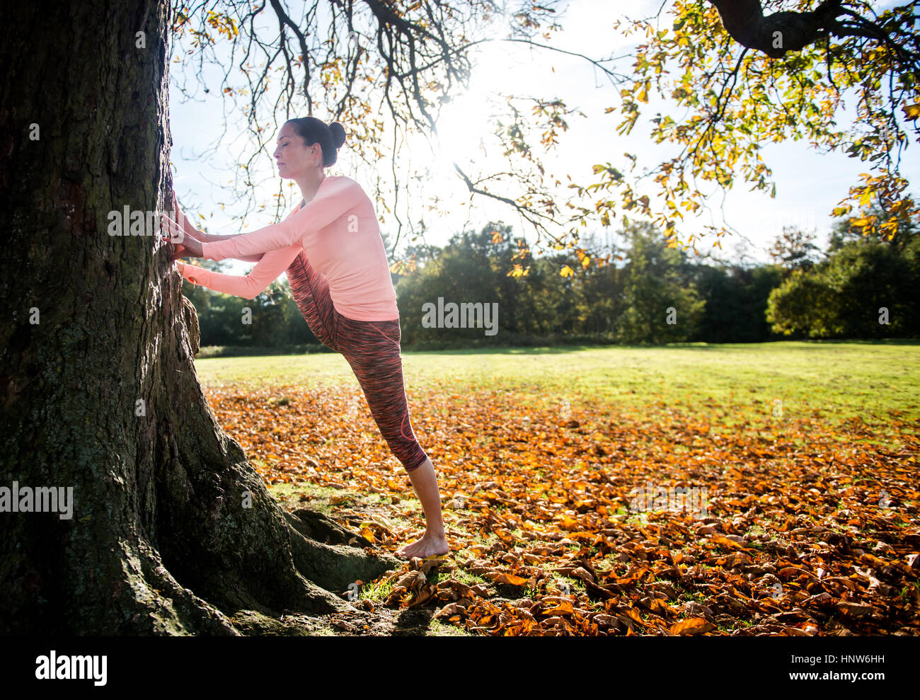 Donna facendo yoga nel parco sulla giornata autunnale Foto Stock