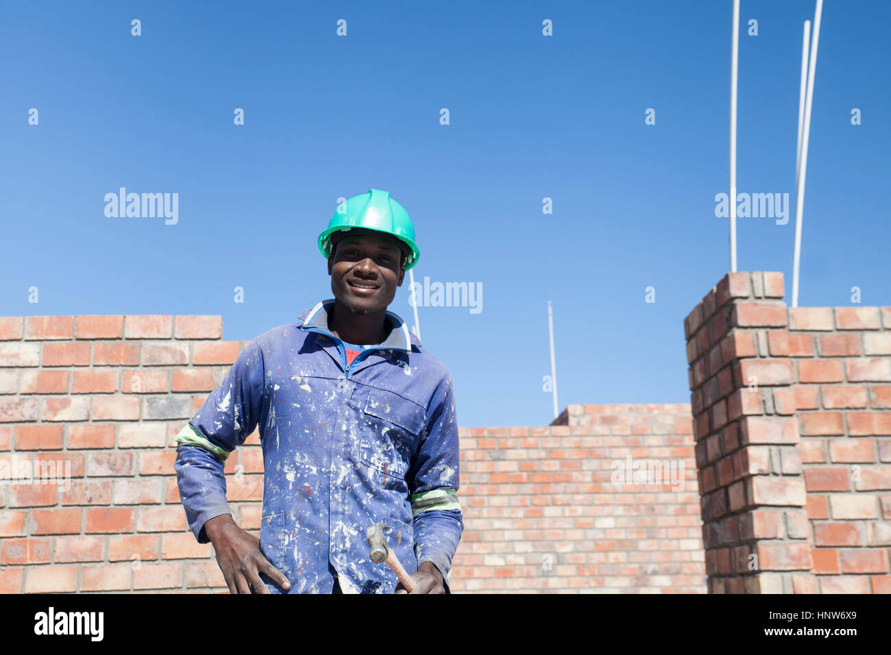 Ritratto di builder indossare elmetto guardando sorridente della fotocamera Foto Stock