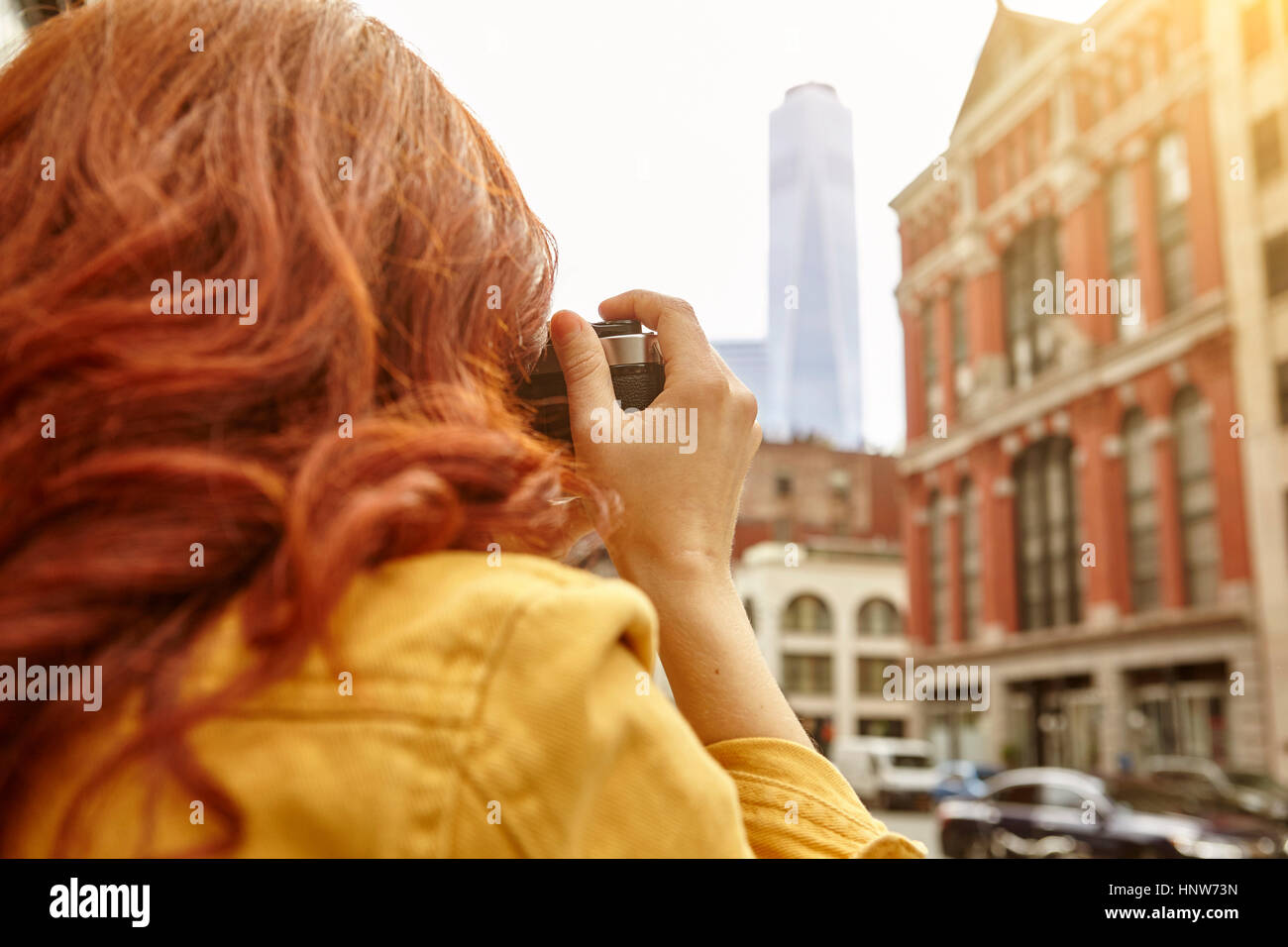 Giovane turista femminile con lunghi capelli rossi a fotografare una World Trade Center, Manhattan, New York, Stati Uniti d'America Foto Stock