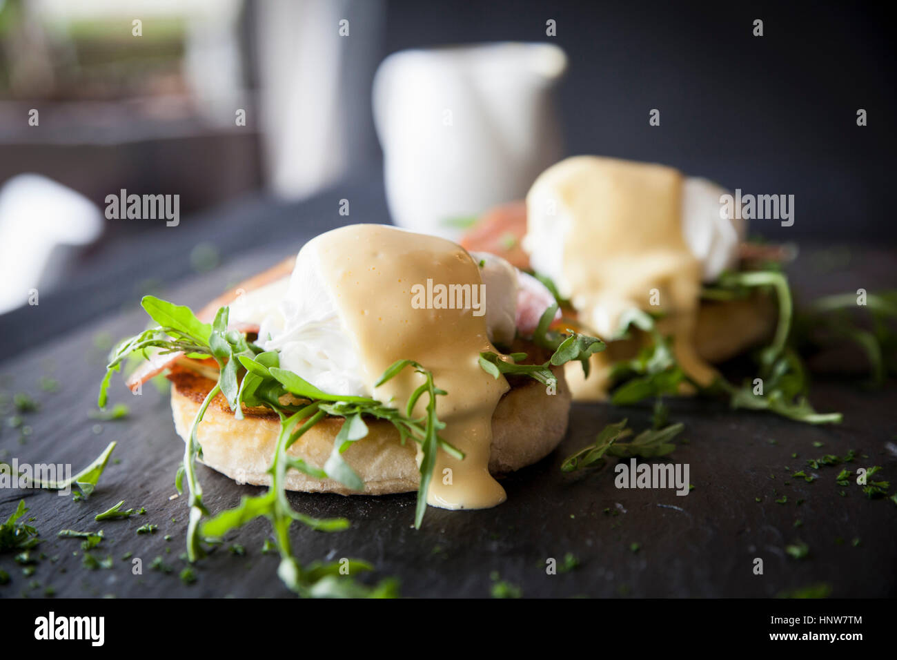 Salsa Olandese su uova Benedict colazione sull'ardesia Foto Stock