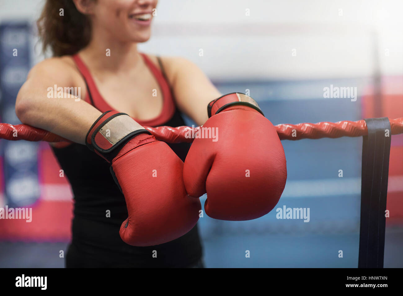 Ritagliato colpo di giovani femmine boxer appoggiata su boxe funi ad anello Foto Stock