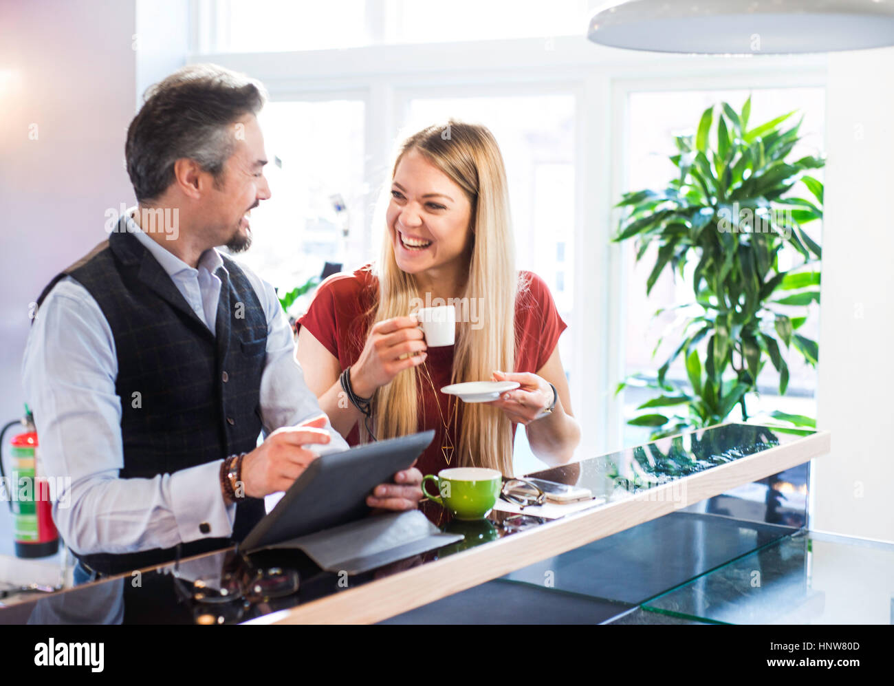 Imprenditore e la donna ridendo durante la pausa caffè in ufficio Foto Stock