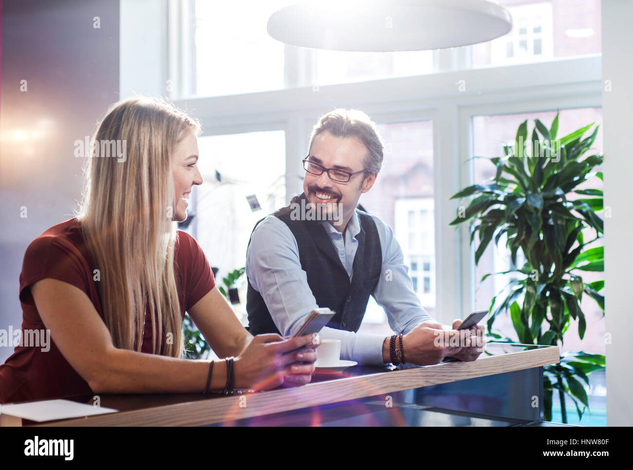 Imprenditore e la donna chiacchierando durante la pausa caffè in ufficio Foto Stock