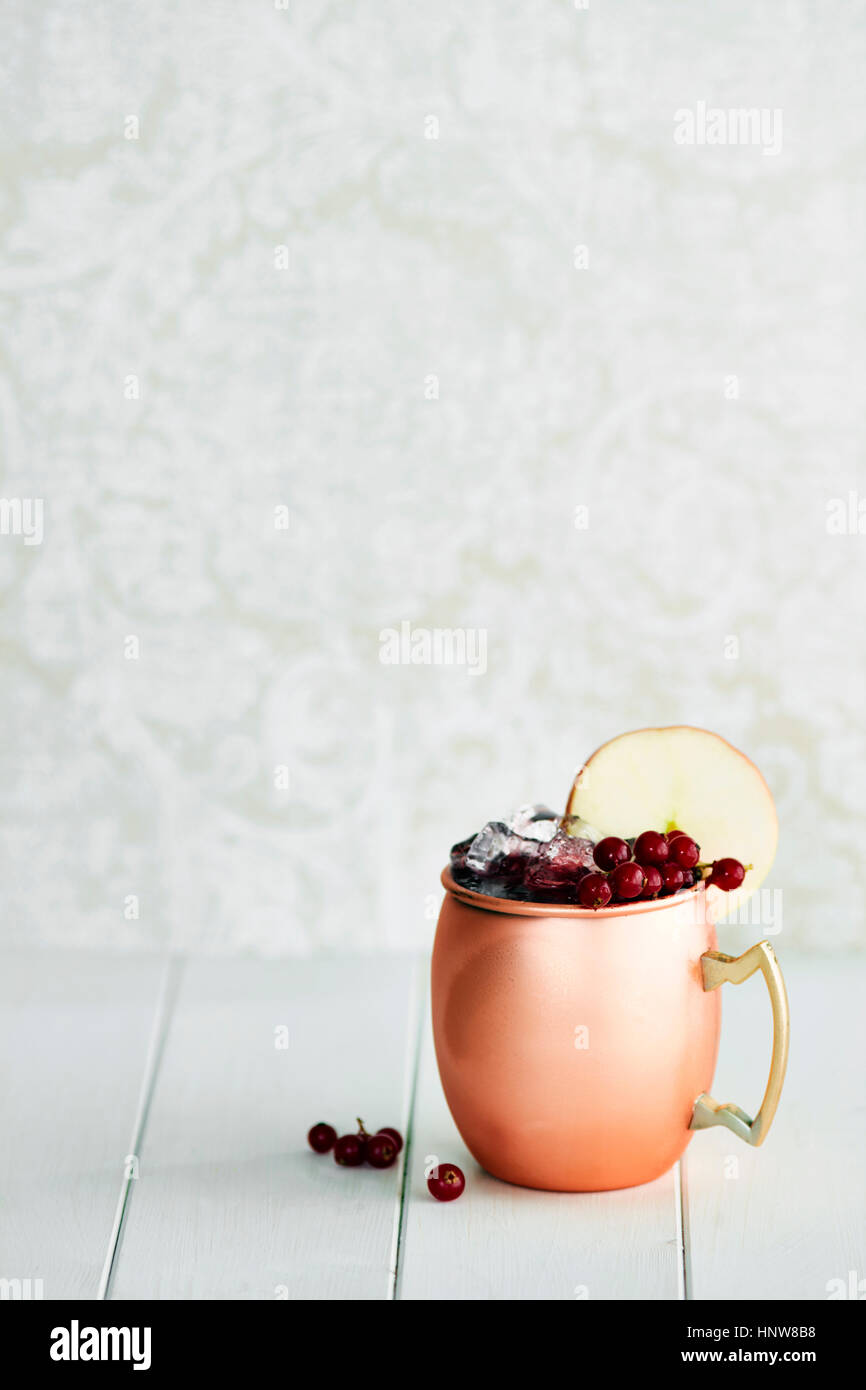 Cocktail analcolico nella tazza di rame con frutti di bosco e fetta di Apple Foto Stock