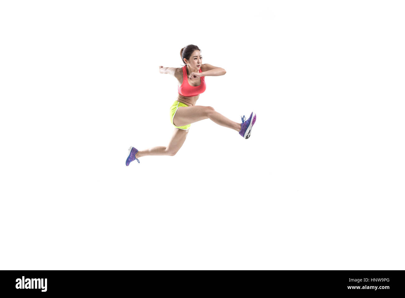 Vista laterale di atleta femminile jumping Foto Stock