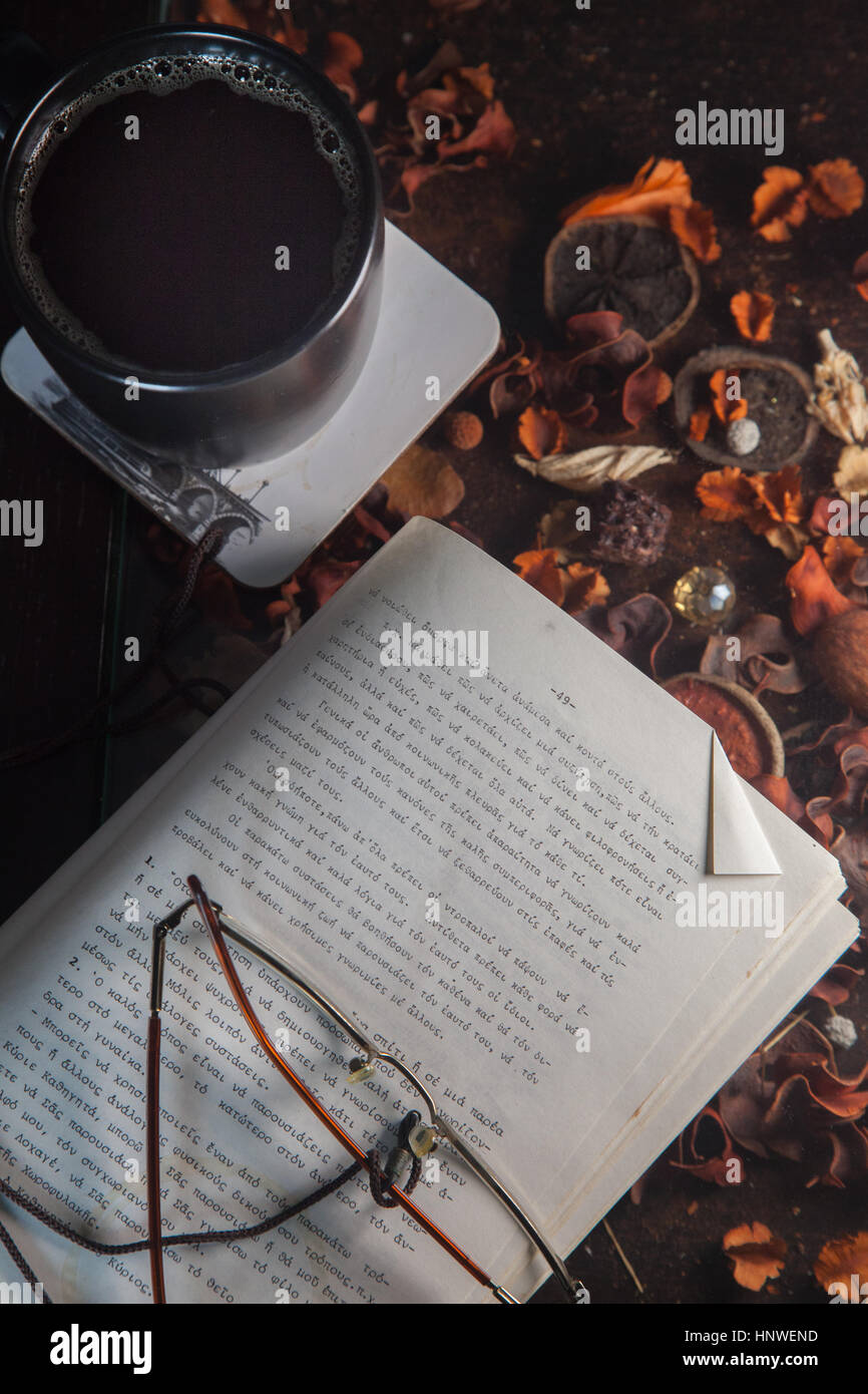 Al di sopra di vista della tazza da caffè con occhiali un libro e lo sfondo colorato Foto Stock