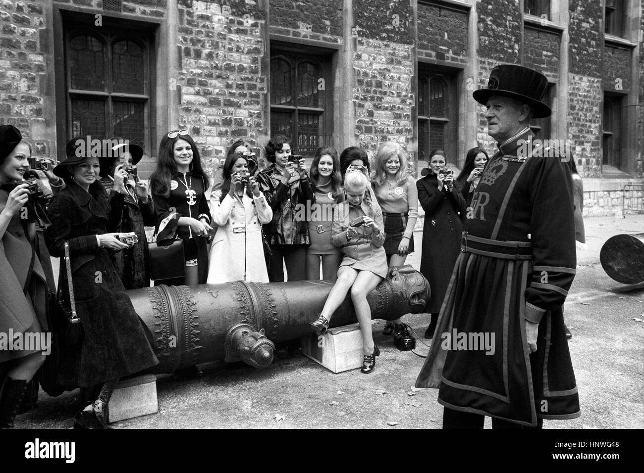 Miss Mondo concorrenti di scattare una foto di Yeoman carceriere Percy Belson, della Torre di Londra, durante il loro tour della città. Foto Stock