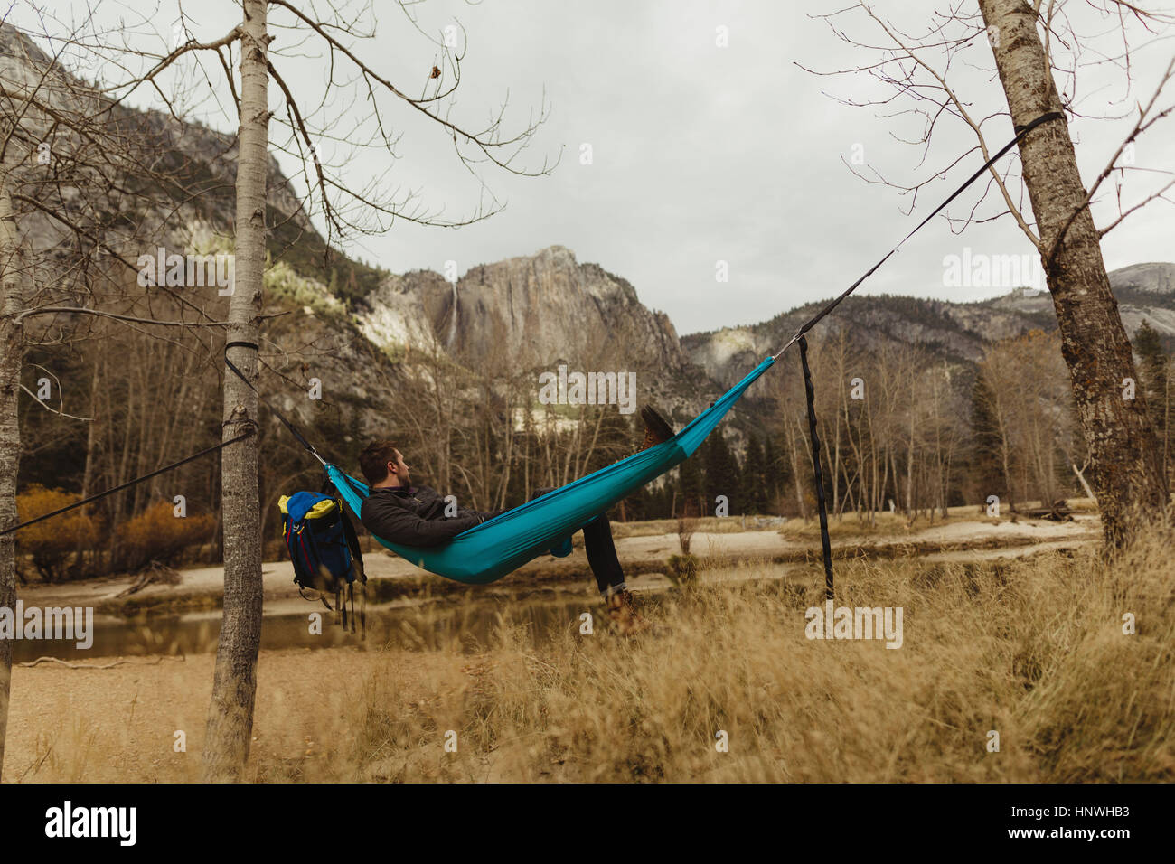 Uomo in reclinabili amaca a guardare il paesaggio, Yosemite National Park, California, Stati Uniti d'America Foto Stock