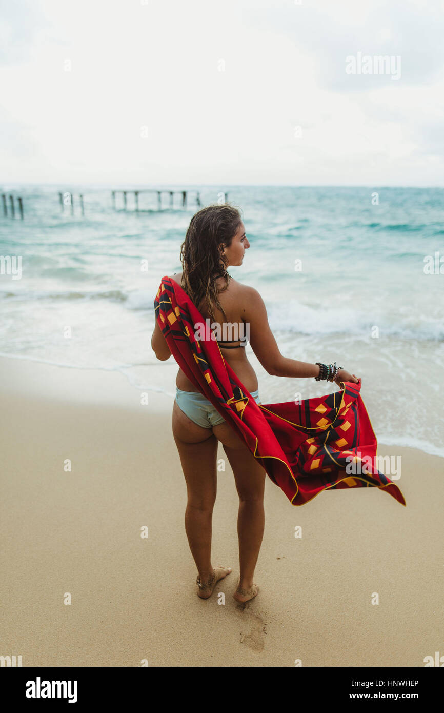 Vista posteriore della donna sulla spiaggia essiccando con asciugamano, Oahu, Hawaii, STATI UNITI D'AMERICA Foto Stock