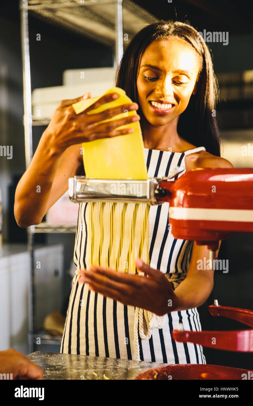 Studente di pasta di appiattimento con pasta maker Foto Stock