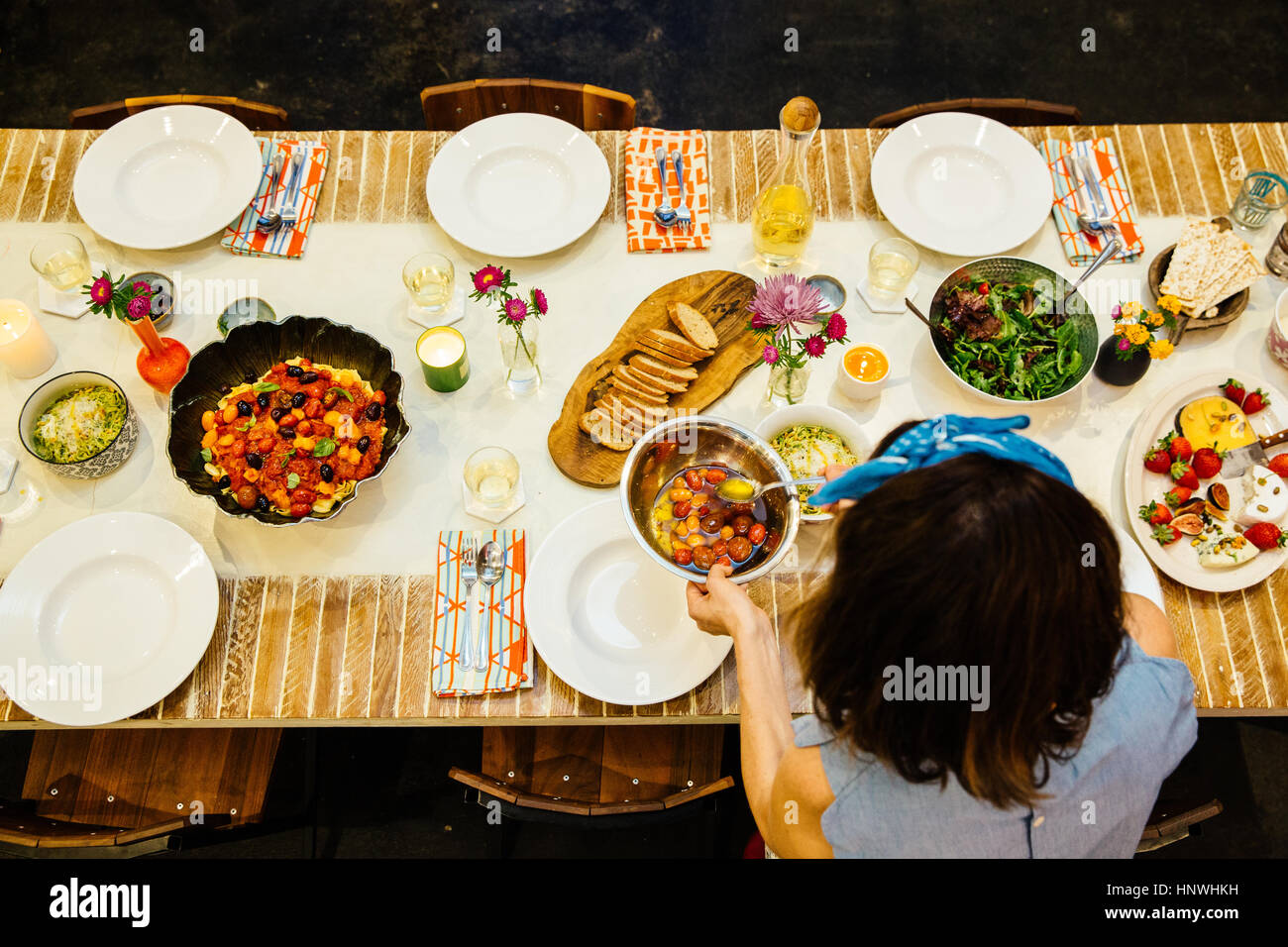 Donna immissione piatto sul tavolo da pranzo Foto Stock