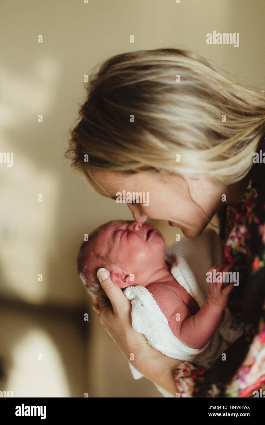 Metà donna adulta naso a naso con neonato figlia Foto Stock