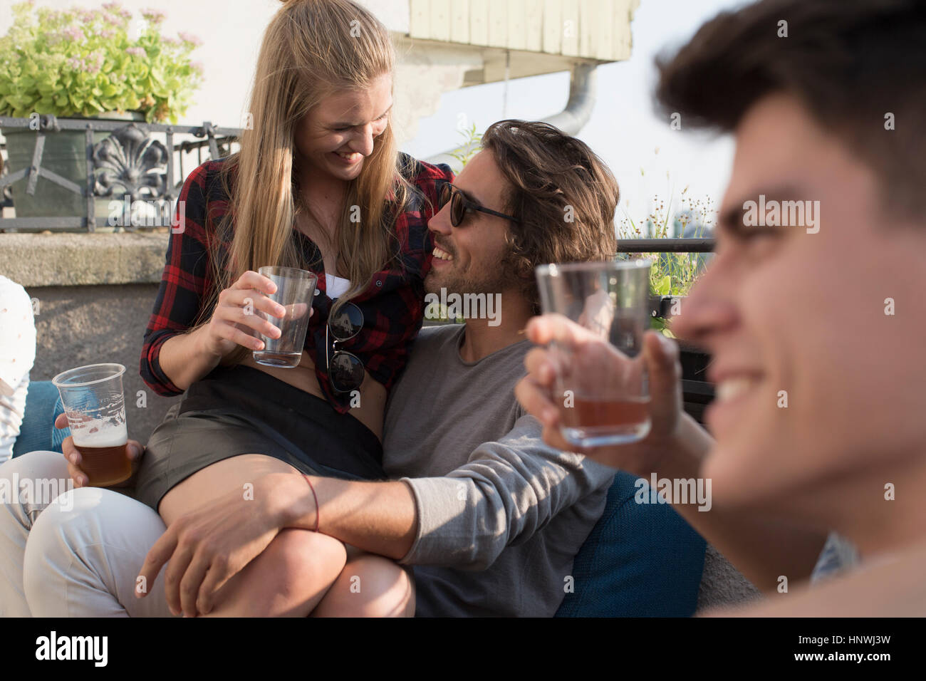 Amici adulti di rilassarsi con un drink in terrazza sul tetto delle parti Foto Stock