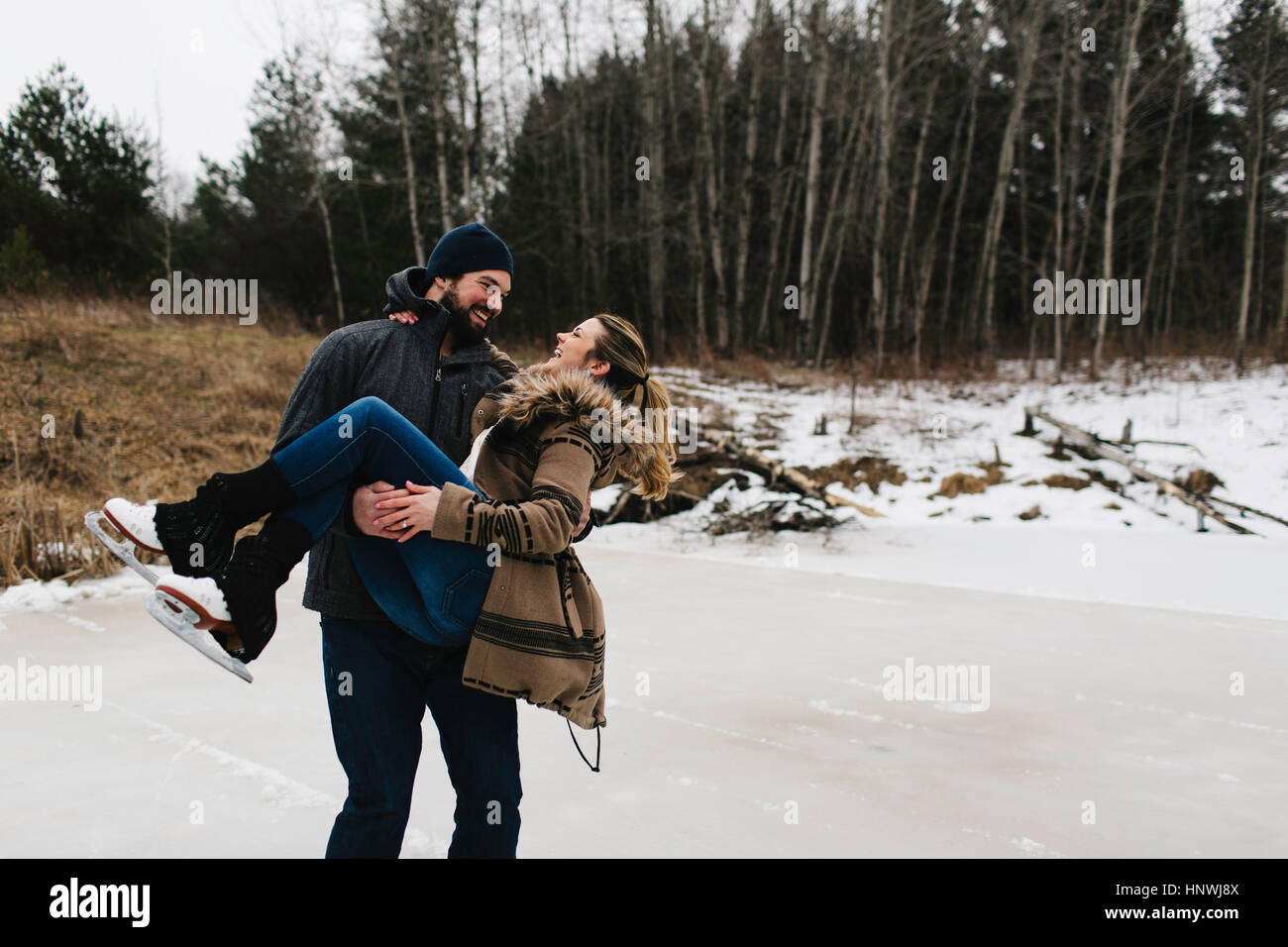 Pattinaggio di uomo con la donna nelle sue braccia, Whitby, Ontario, Canada Foto Stock