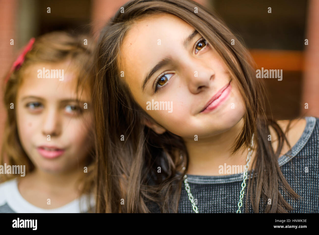 Ritratto di fiducioso ragazza di fronte di sua sorella Foto Stock