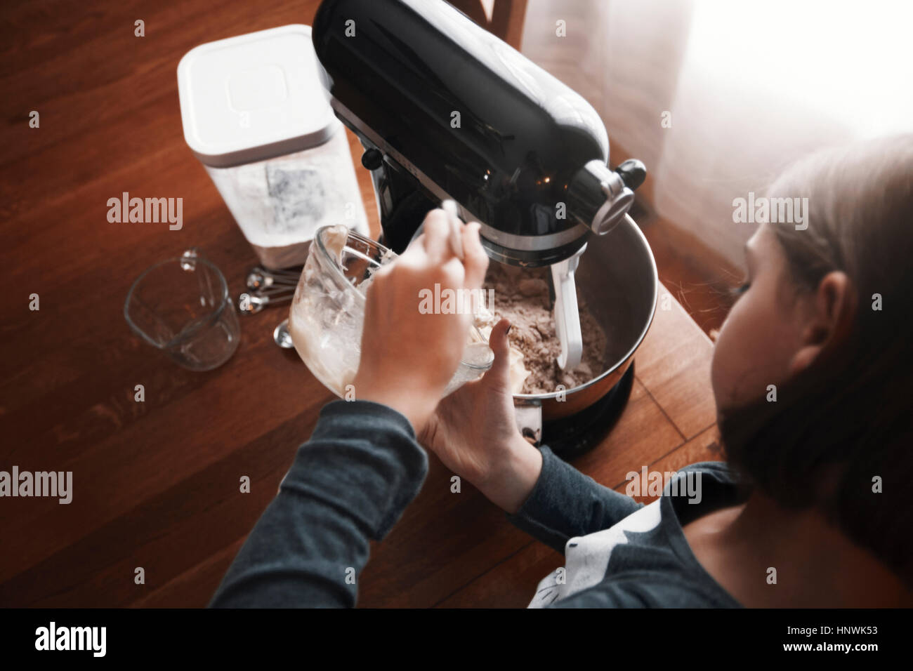 Ragazza giovane versando gli ingredienti nel vaso del frullatore, vista aerea Foto Stock