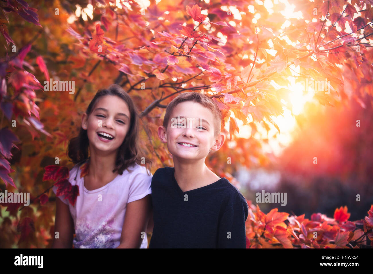 Ritratto di un ragazzo e una ragazza in ambiente rurale al tramonto, ridendo Foto Stock