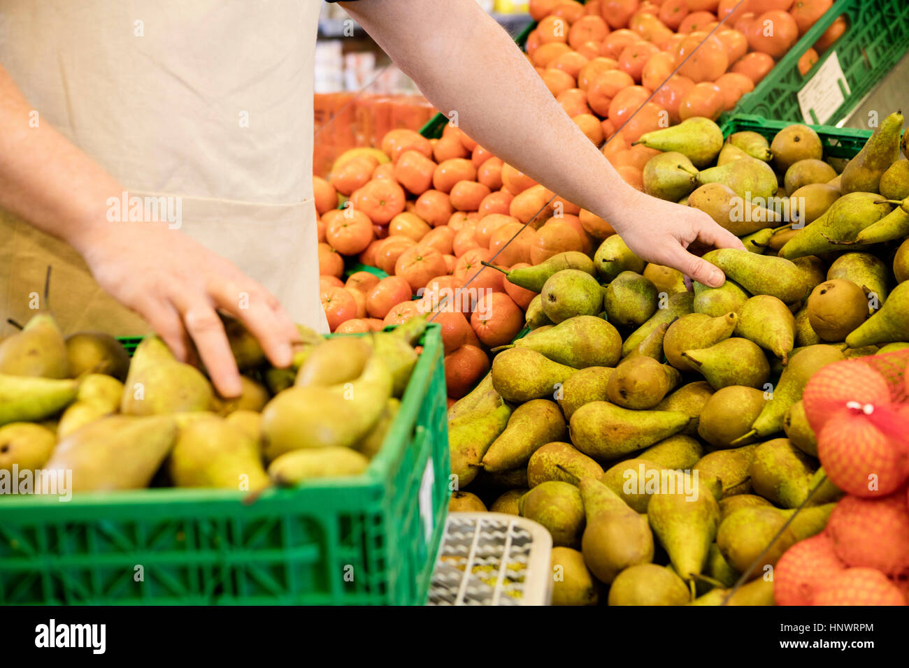 Sezione mediana del venditore disponendo pere fresche Foto Stock