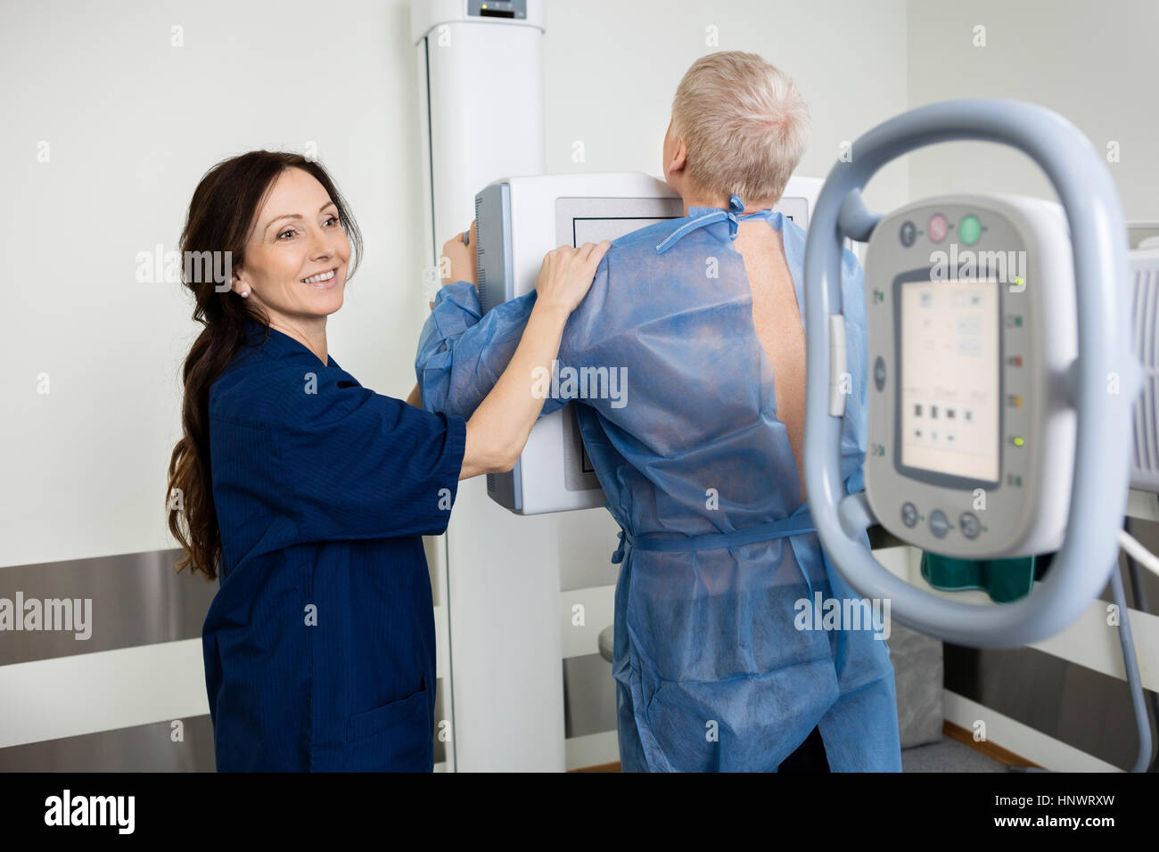 Felice radiologo tenendo xray dell uomo in ospedale Foto Stock