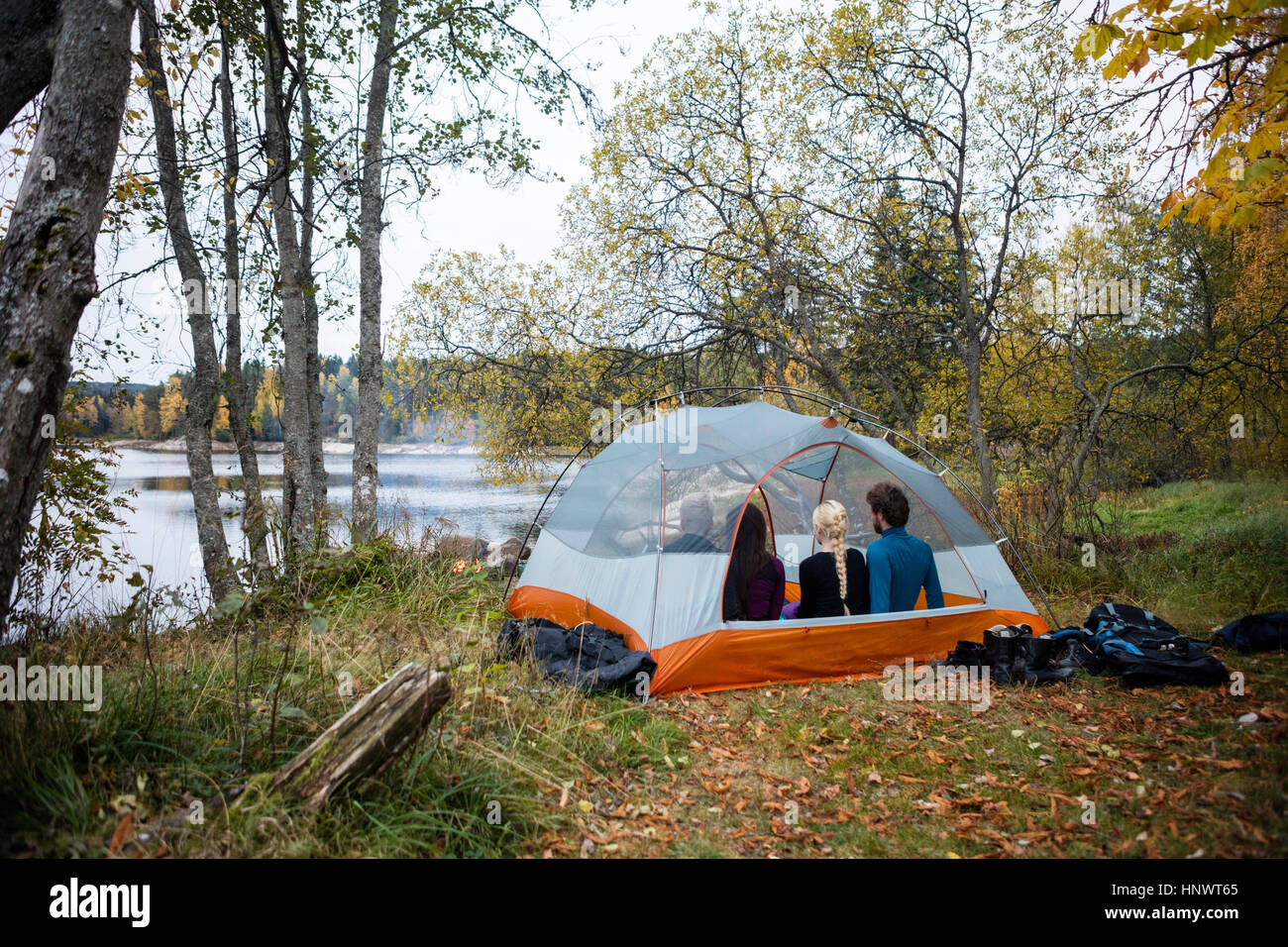 Amici rilassante in tenda sul lungolago Foto Stock