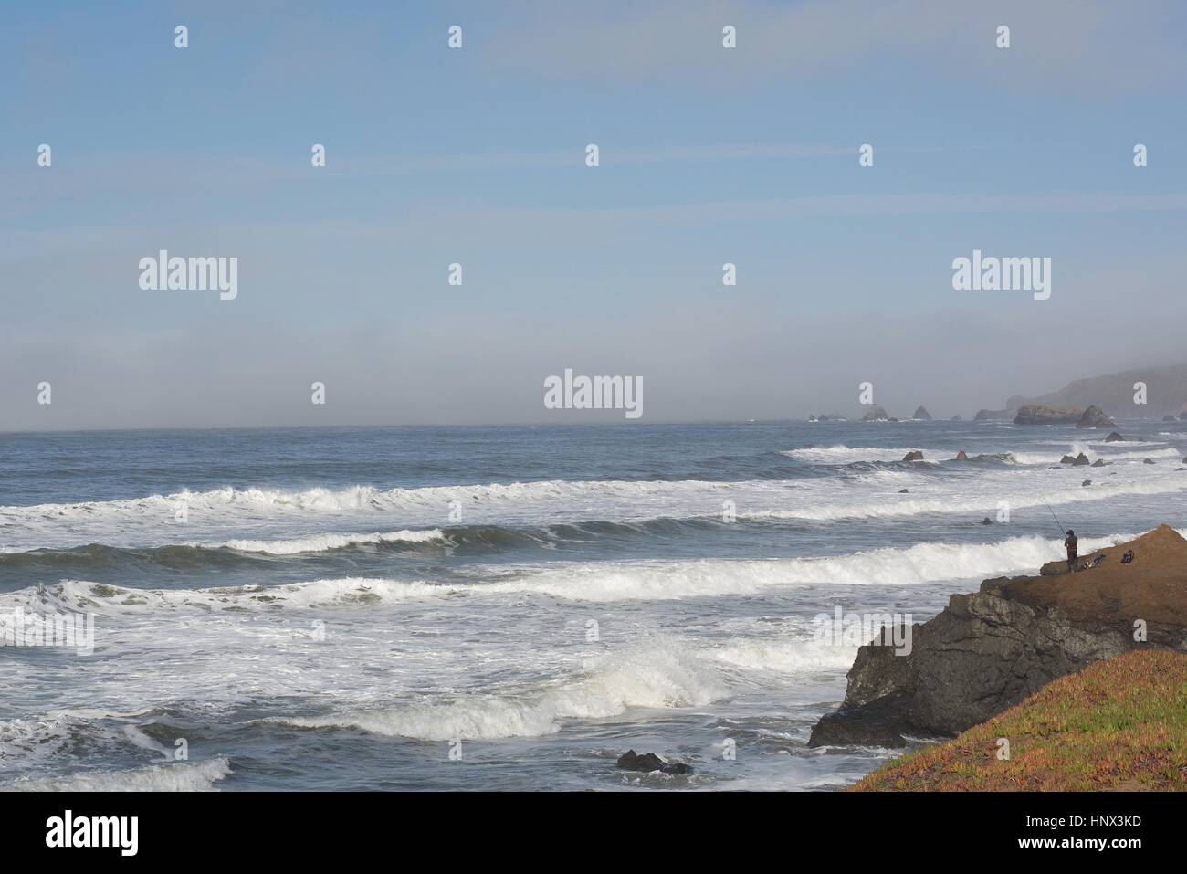 Una persona che pesca da una scogliera di Dillon Beach in California del nord, STATI UNITI D'AMERICA. Foto Stock