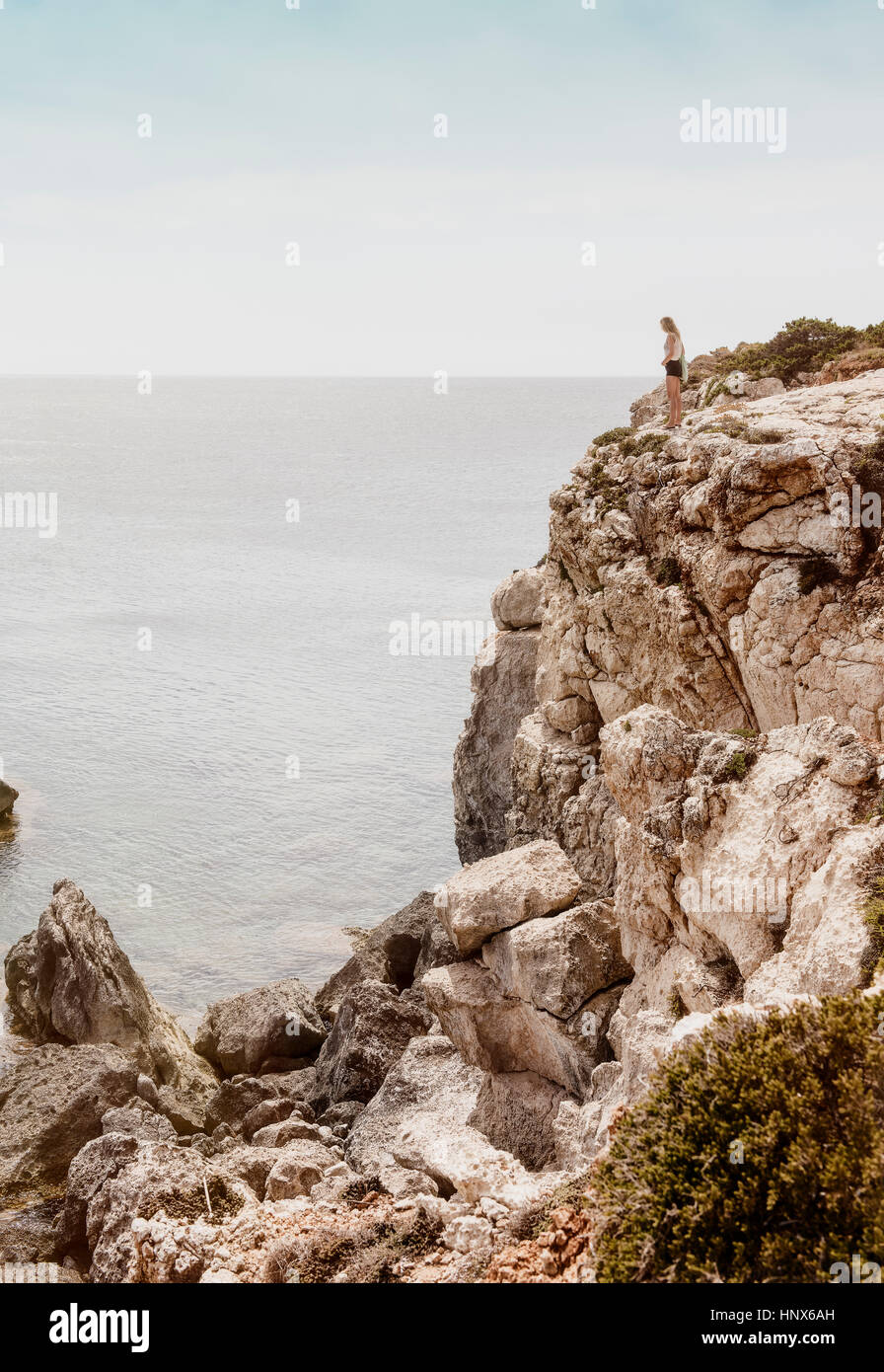Donna in piedi sulla scogliera, Menorca, Spagna Foto Stock