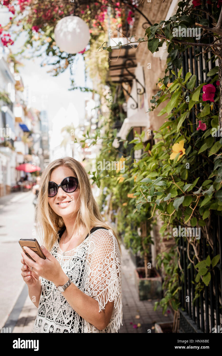 Donna in strada guardando la telecamera sorridendo, Marbella città vecchia, Spagna Foto Stock