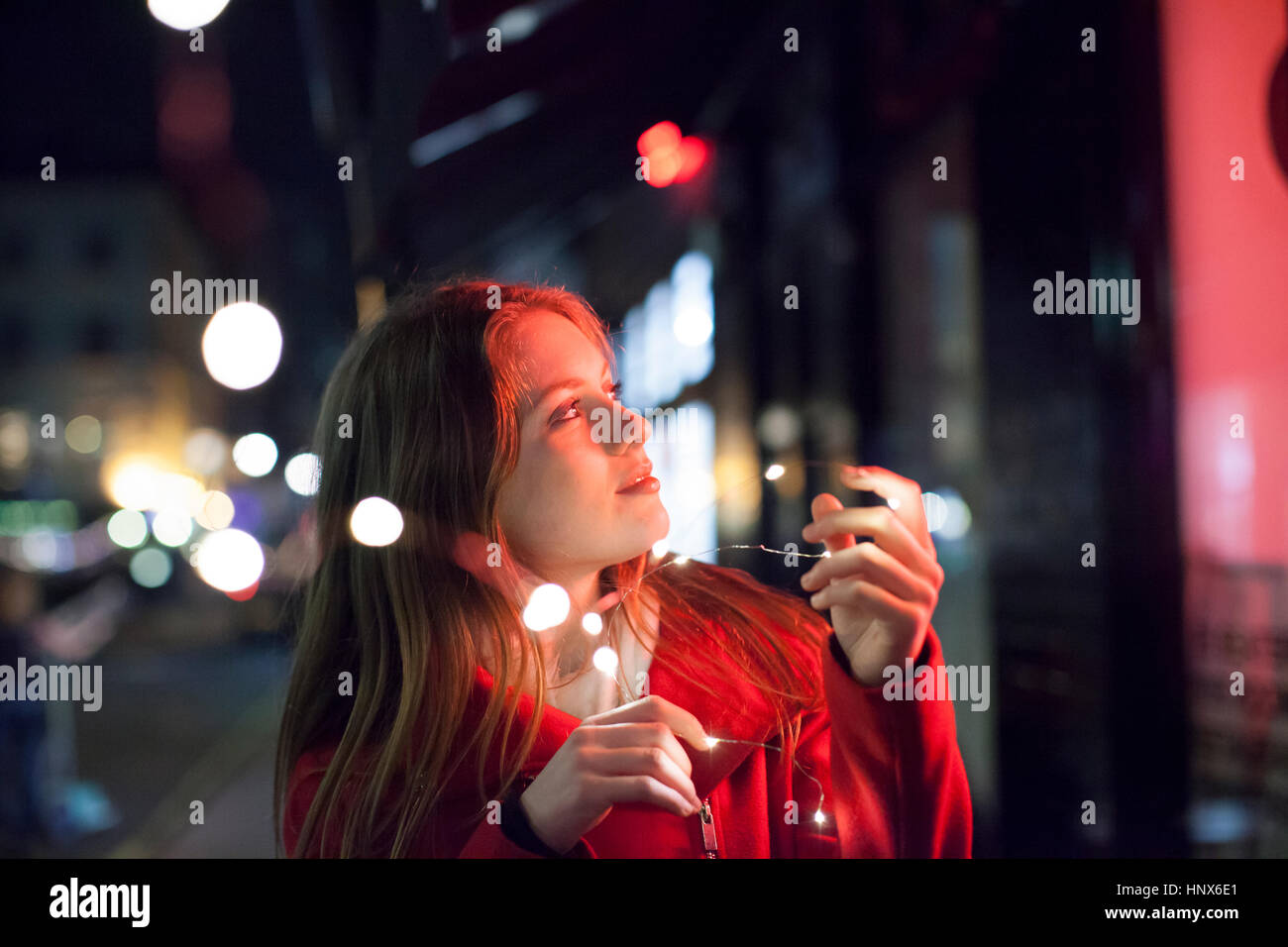 Giovane donna godendo di luci luminose di Street, Londra, Regno Unito Foto Stock