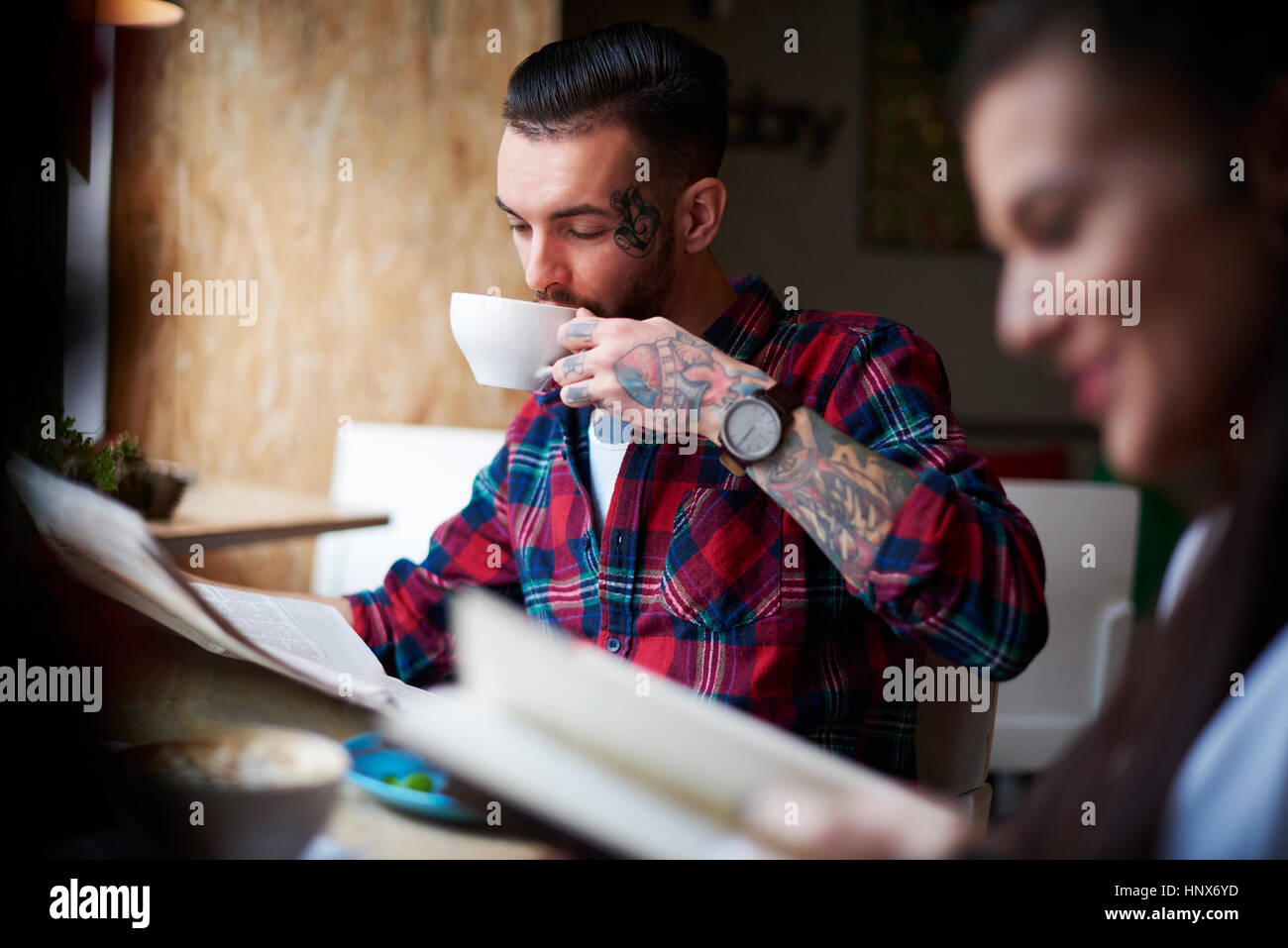 Paio di bere il caffè la lettura quotidiani Foto Stock