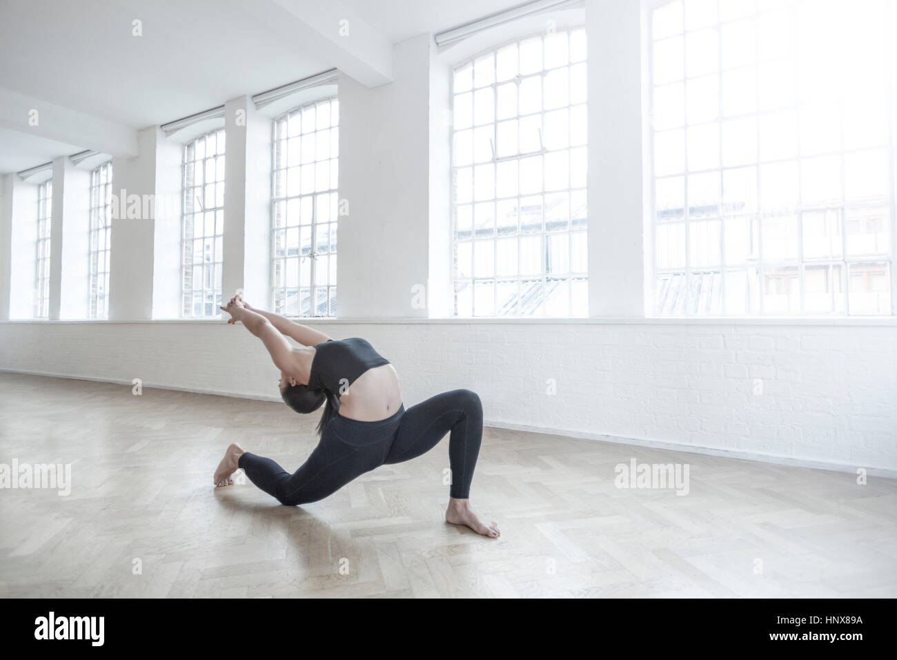 Donna in dance studio flessione all'indietro stretching Foto Stock