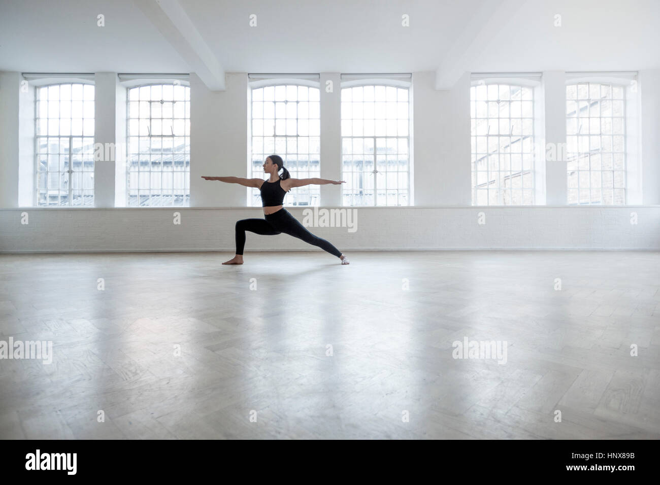 Donna in studio di danza in posizione di yoga Foto Stock