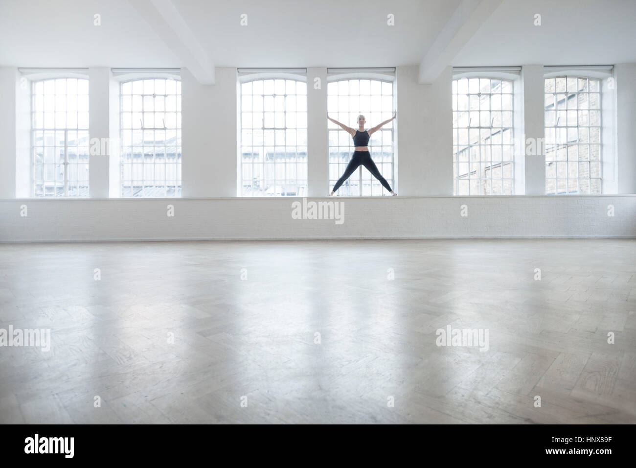 Donna sul davanzale in studio di danza Foto Stock