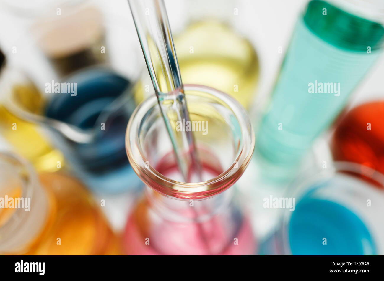 Pipettare nel pallone da laboratorio contenenti sali di metalli di transizione Foto Stock