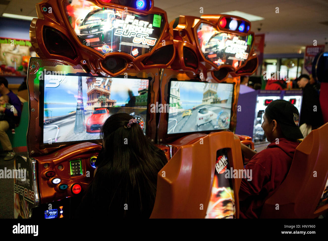 Persone giocare auto racing video game in galleria video - USA Foto Stock