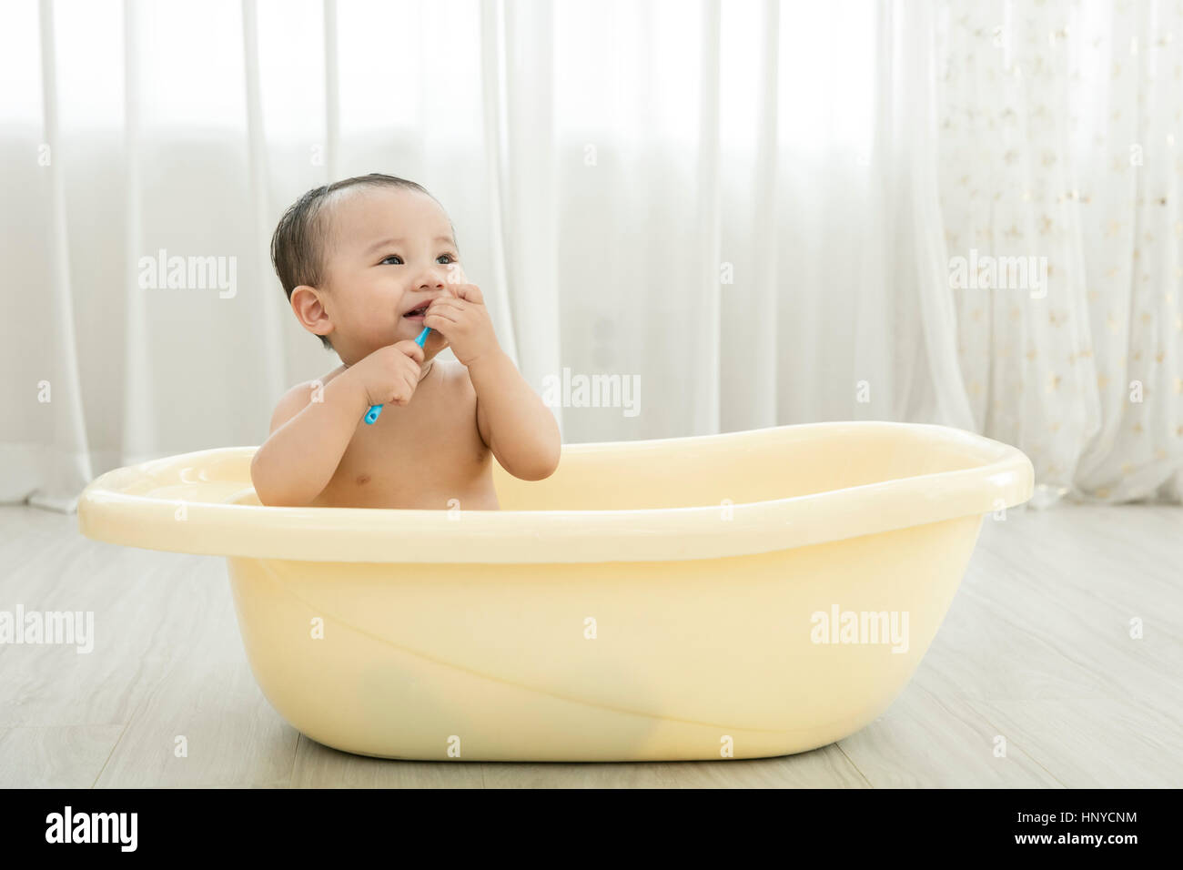 Sorridente baby boy in una vasca da bagno Foto Stock