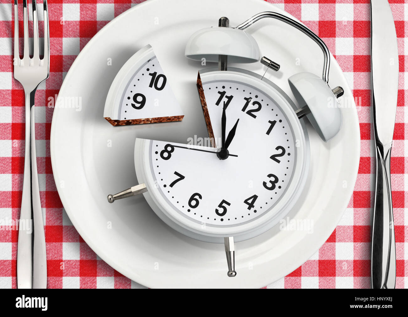 Il tempo di mangiare concetto, tagliare l'orologio su piastra Foto Stock