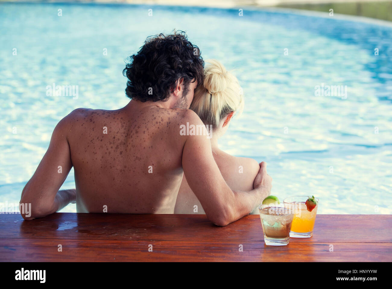 Coppia insieme rilassante in piscina, vista posteriore Foto Stock