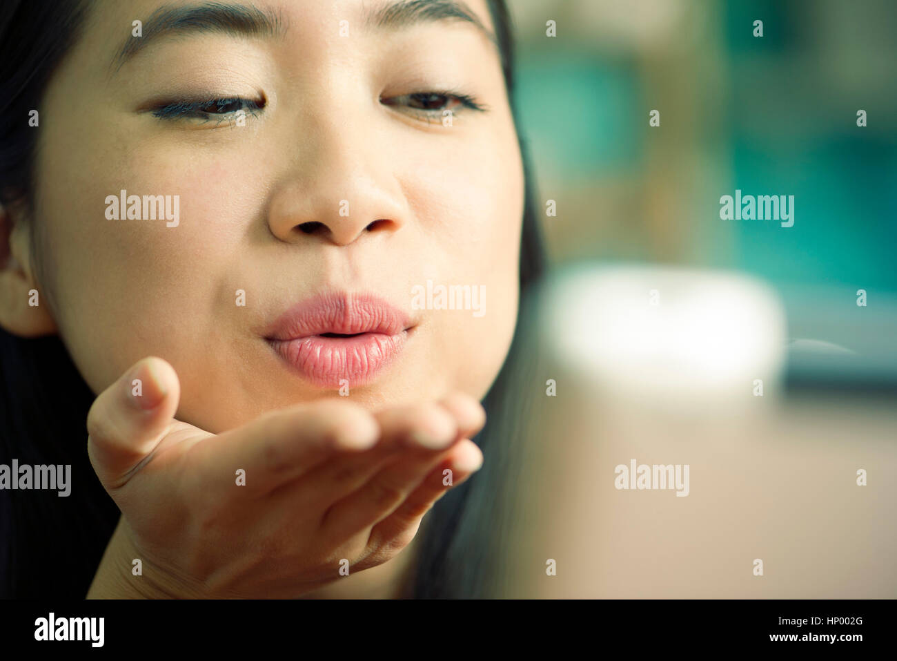 Giovane donna bacio di soffiaggio in telecamera durante le videoconferenze Foto Stock