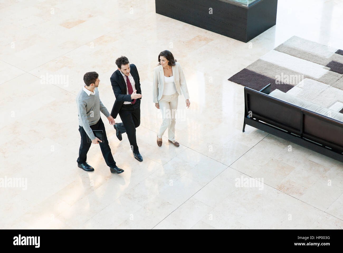 Business Associates camminare insieme nella lobby di office Foto Stock