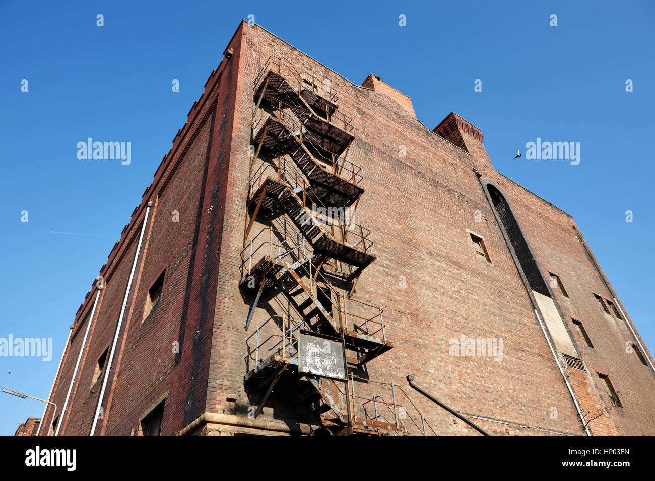 Metallo vecchio fire escape sul lato di Red Brick Warehouse edificio Dock Liverpool Regno Unito Foto Stock