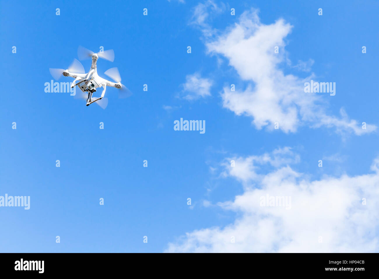 Quadrocopter in cielo molto nuvoloso, compatto bianco drone controllato dal telecomando wireless Foto Stock