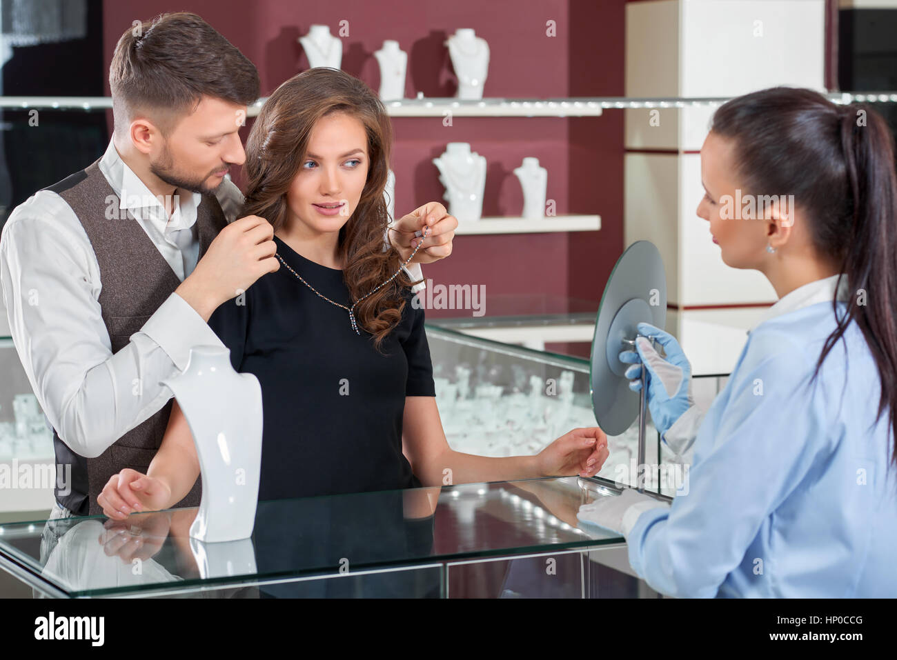 Giovane uomo aiutando la sua fidanzata con raccordo a collana in je Foto Stock