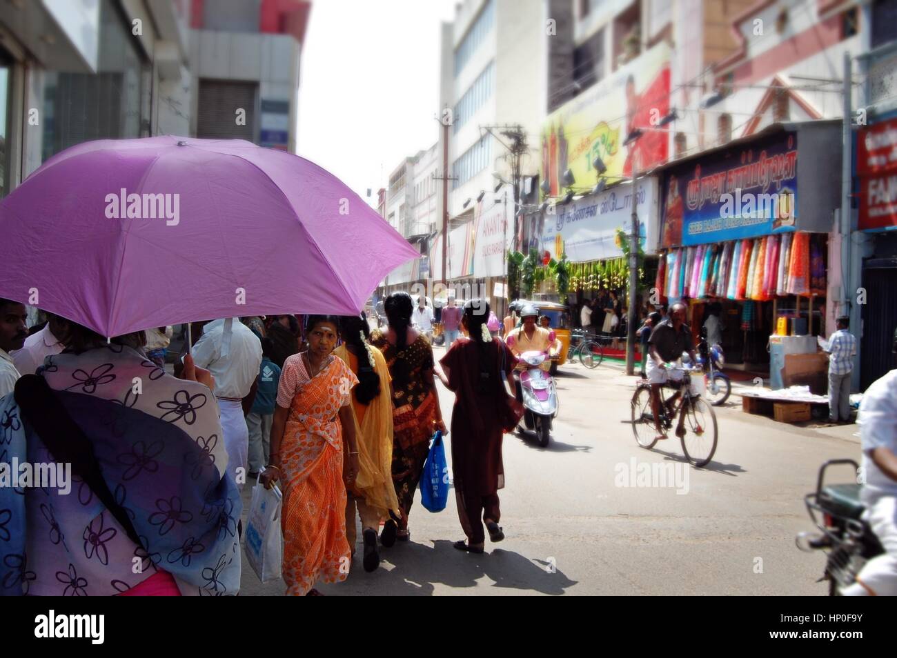Usando un ombrello come un ombrellone nel caldo sole su un Indiano street, Thanjavur ( Tanjore) in Tamil Nadu, nell India meridionale Foto Stock