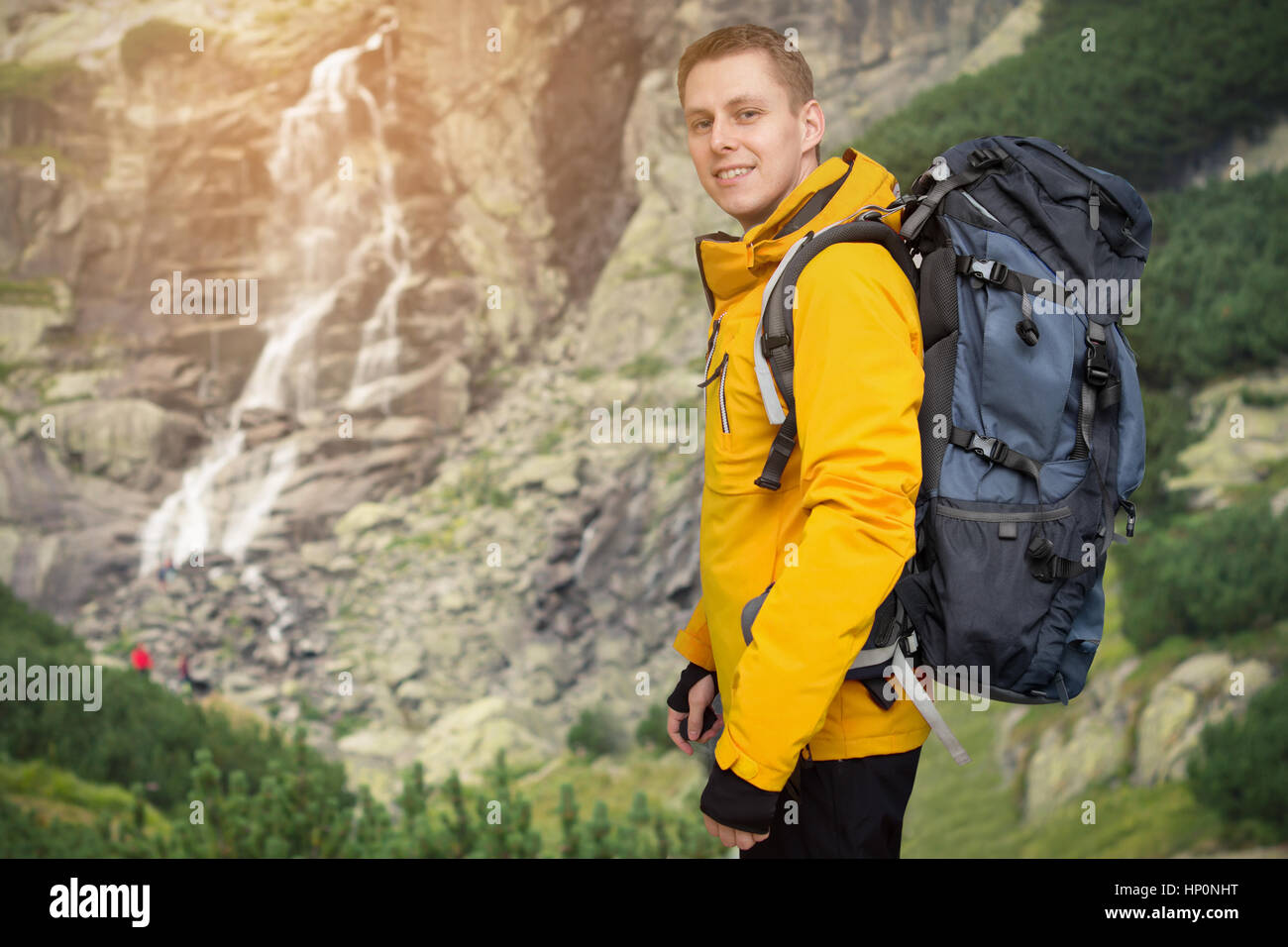 Escursionista uomo con zaino in piedi a cascata Foto Stock