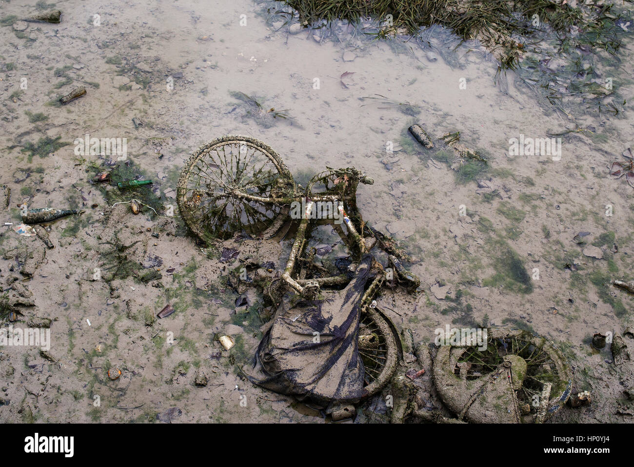 Vecchia bicicletta nel flusso inquinato Foto Stock