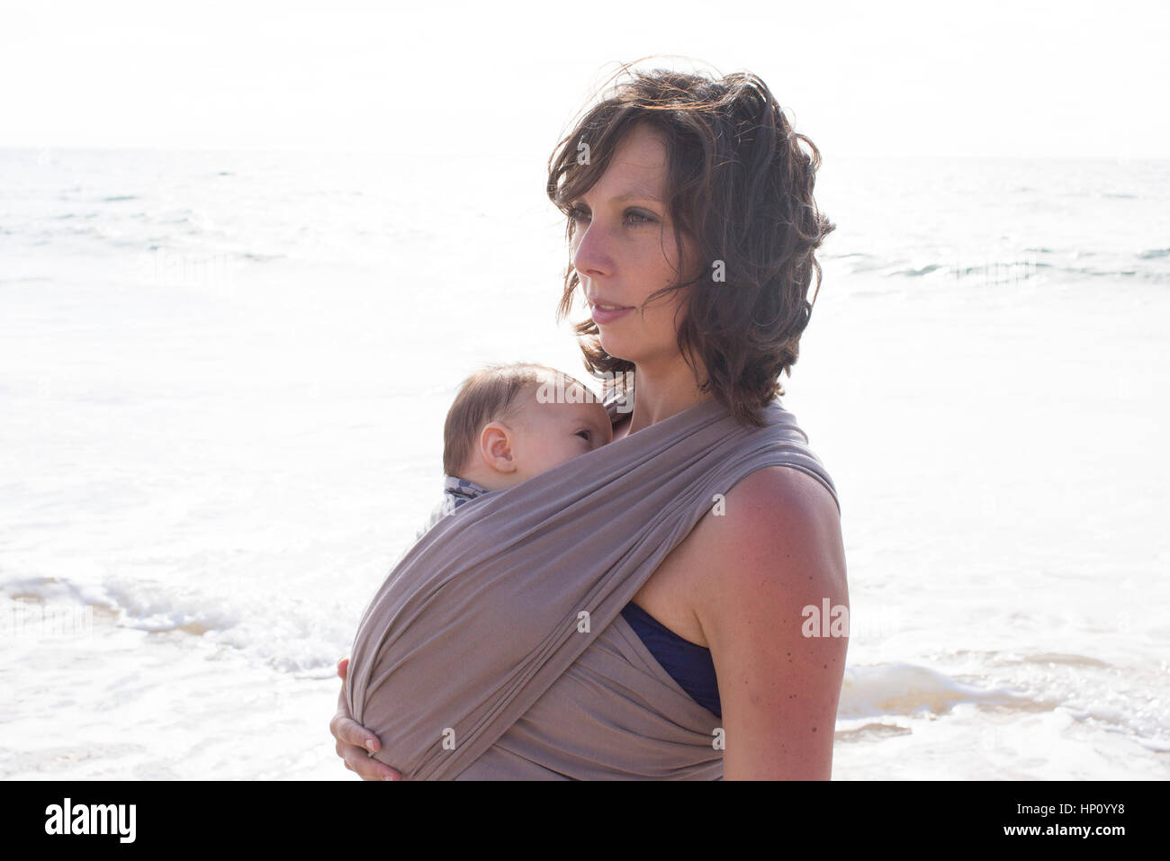 Madre indossa baby in wrap Foto Stock