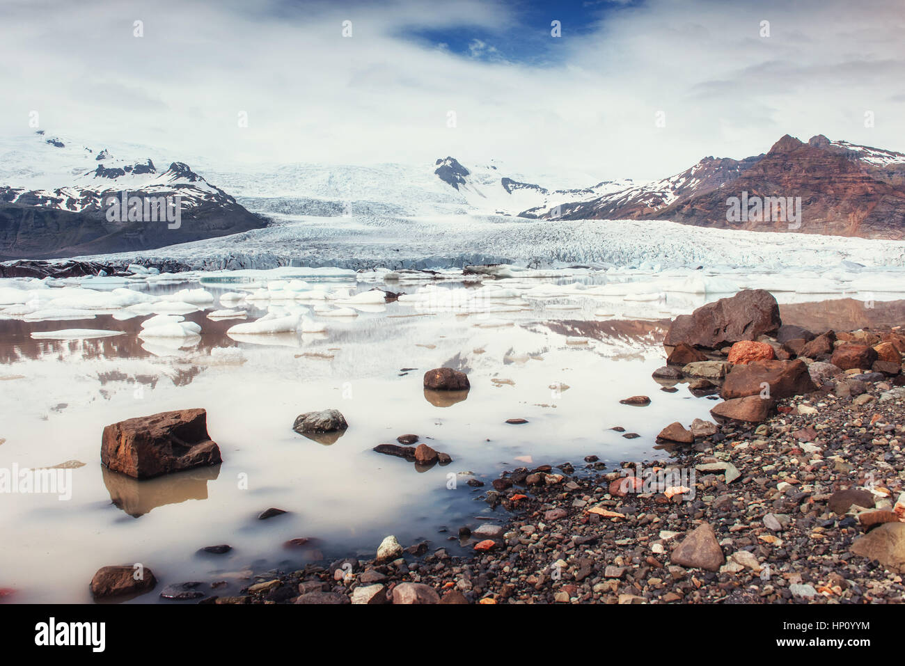Iceberg laguna glaciale Fjallsarlon. Cumulus nuvole bianche riflettono Foto Stock